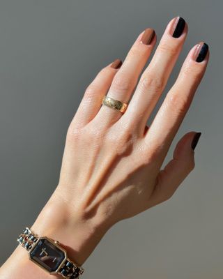 An image of woman's hand showing of her nail art and wearing hand cream.