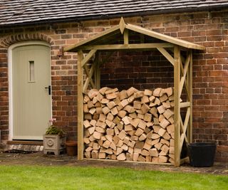 Large Wall Apex Log Store next to a rustic back door