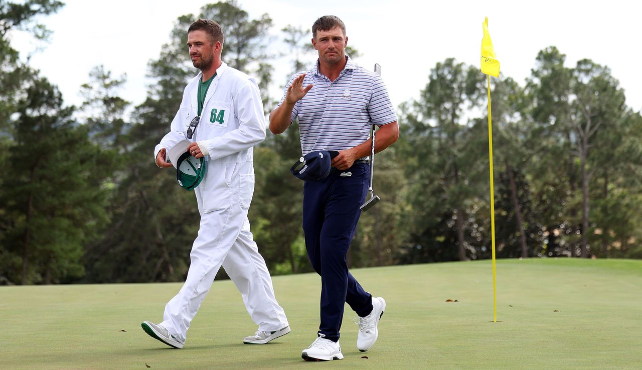 Bryson DeChambeau walks off the 18th green at Augusta National alongside his caddie