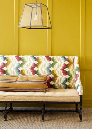 Bench upholstered in Knole in Tapestry from Madeaux, with a cushion in its Berber Stripe in Saffron. The walls are in Little Greene’s Mister David