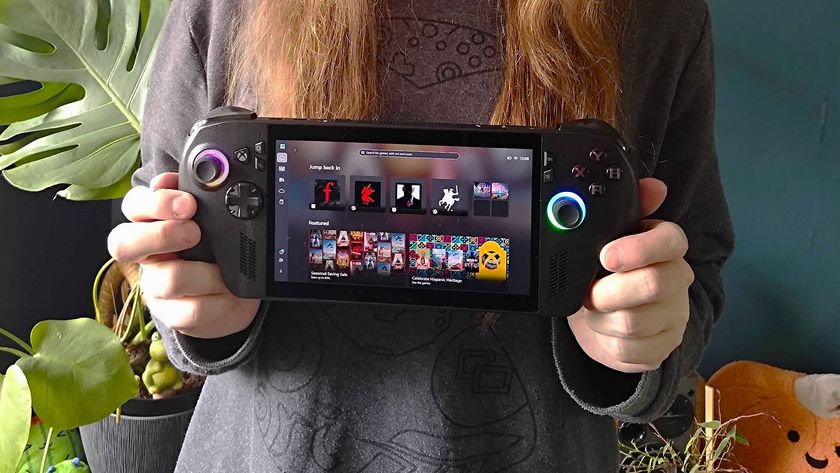 Hands holding ROG Xbox Ally X handheld with plants and green wall in backdrop.