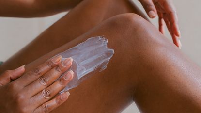 Woman applying shaving cream to her legs.