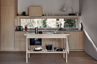 Nordic style kitchen in all wood and a pine trestle table