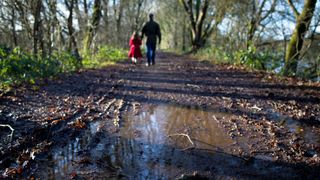 Two people walking on a muddy trail