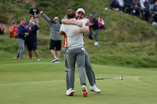 Shane Lowry and Tyrrell Hatton hug after winning a point at the Ryder Cup