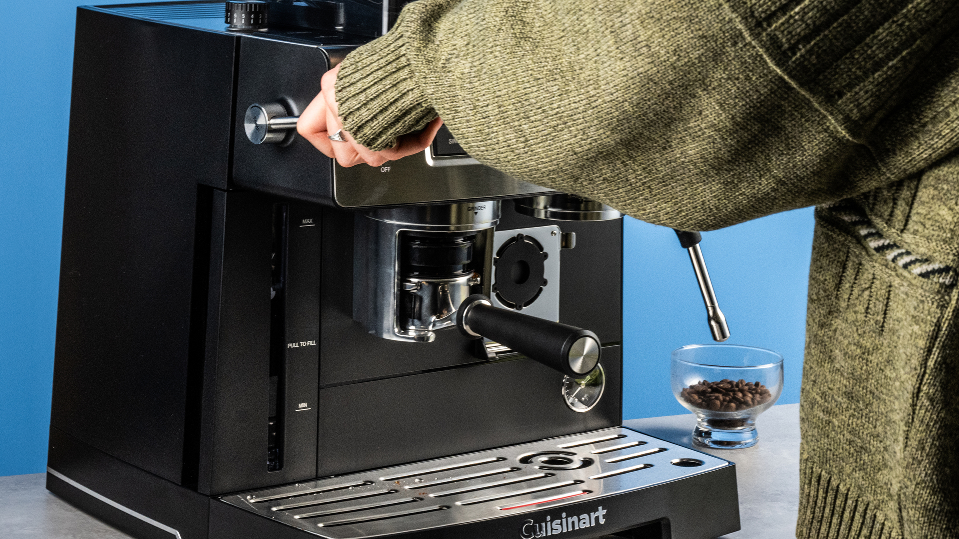 the cuisinart grind, tamp and brew espresso machine with built-in grinder photographed against a blue tom's guide background