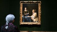 A woman looks at the Vermeer painting "Mistress and Maid" at The Frick