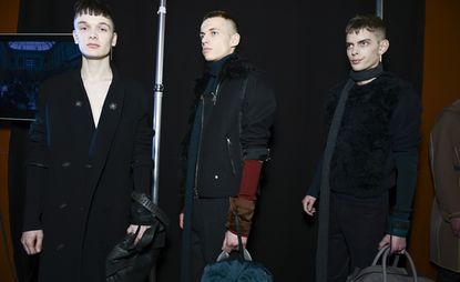 Three male models wearing dark clothing