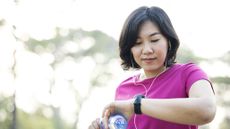 How to lose fat and gain muscle: Image shows woman looking at fitness tracker