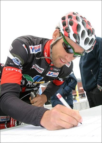 A member of Norway's Plussbank Cervelo squad signs in.