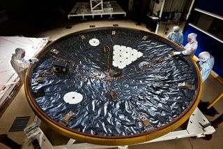 Technicians at Lockheed Martin in Denver finalize the installation of the MEDLI instrument package on the backside of the Mars Science Laboratory's heat shield.