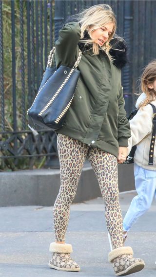 Sienna Miller wearing leopard print leggings, green parka coat and Gucci UGG boots