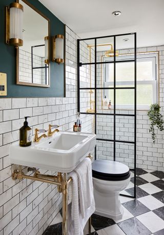 A bathroom idea by interior designer Nicola Miller with black framed shower door, checkered flooring and white metro tiles