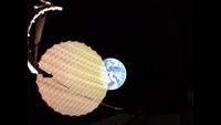 A circular, yellow honeycomb pattern reflector that is semi-transparent overlaps in front of the left third of Earth against the black of space.