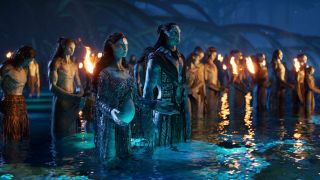 Jake and Neytyri stand in the water with other Na'vi in Avatar: The Way of Water.