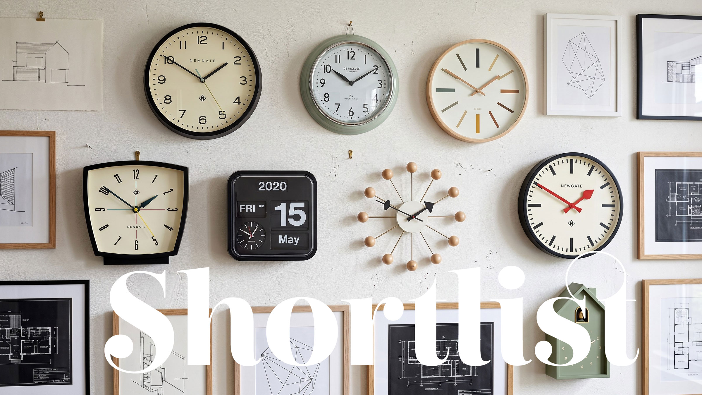 Clocks in a collection on a white wall with pictures