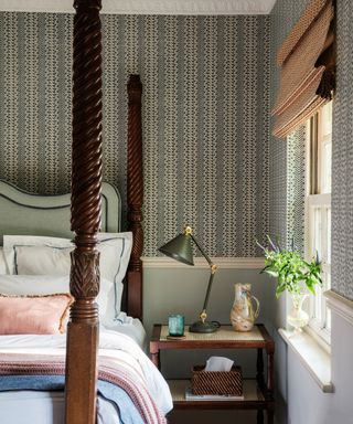 bedroom with four poster bed, nighstand and patterned wallpaper