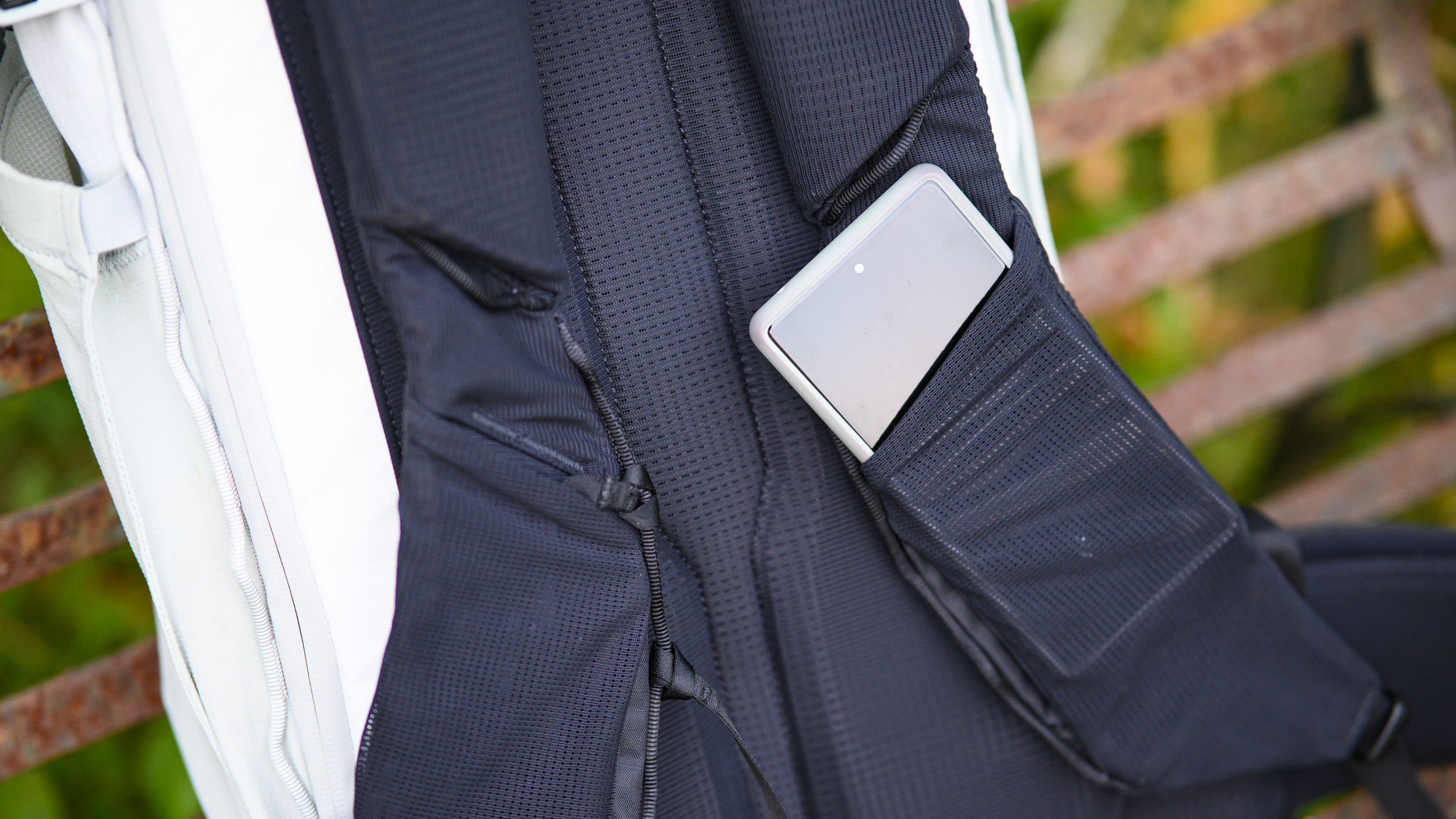 Close up of the Peak Design Outdoor Backpack 25L's shoulder straps with phone inside sleeve