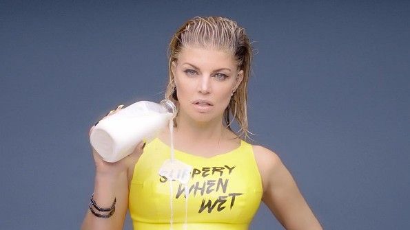 Fergie pours milk over her chest.