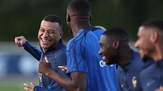 Kylan Mbappe jokes with Ibrahima Konate during a France training session in October 2023.