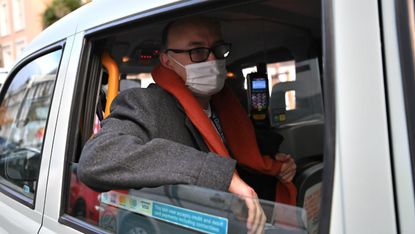 Dominic Cummings in a London black cab wearing a face mask.