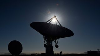 radio telescopes point upward in the desert under a bright sun