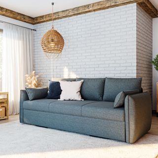 Grey sofa bed in a white room with painted brick walls and rattan lampshade
