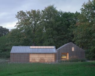 Autobarn by Bindloss Dawes, timber structure lit from within at dusk