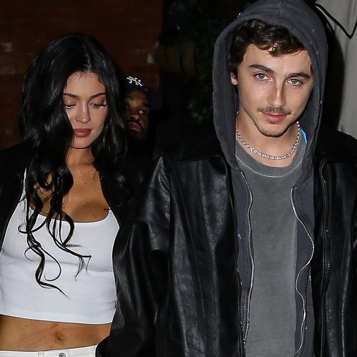 Kylie wears a white tank and timothee wears a hoodie and a leather jacket.