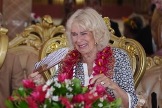 Queen Camilla crying in Samoa while wearing a floral dress