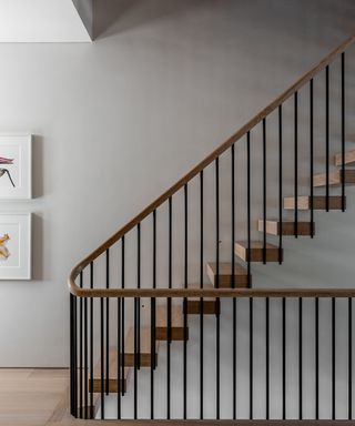 neutral hallway with staircase with floating treads and timber handrail