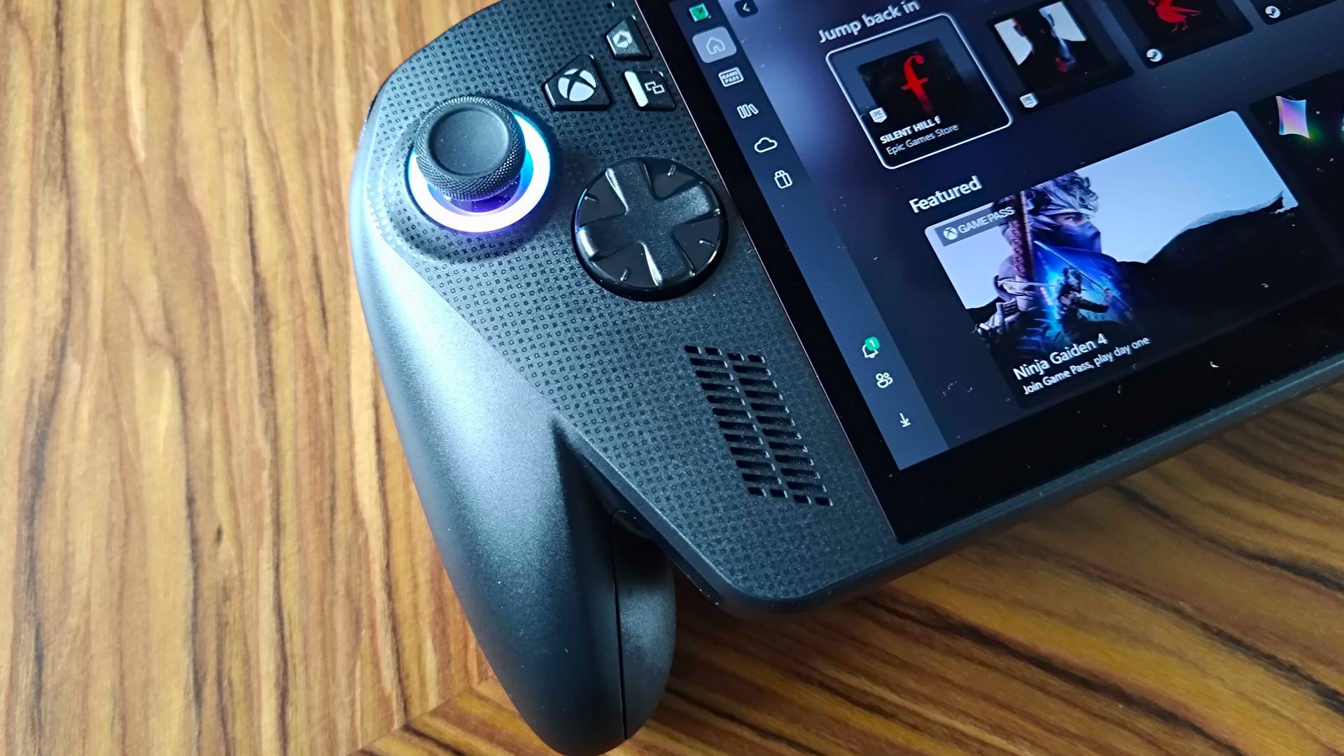 Left side of ROG Xbox Ally X on woodgrain desk.