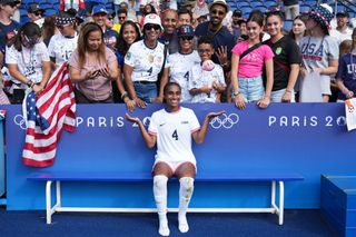 Naomi Girma #4 of the United States poses for a photo with fans after playing Japan during the Women's Quarterfinal match during the Olympic Games Paris 2024 at Parc des Princes on August 03, 2024 in Paris, France.