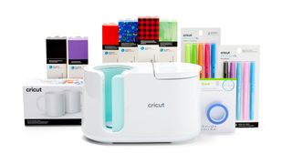 Cricut black friday live blog; a heat press machine surrounded by mugs and materials