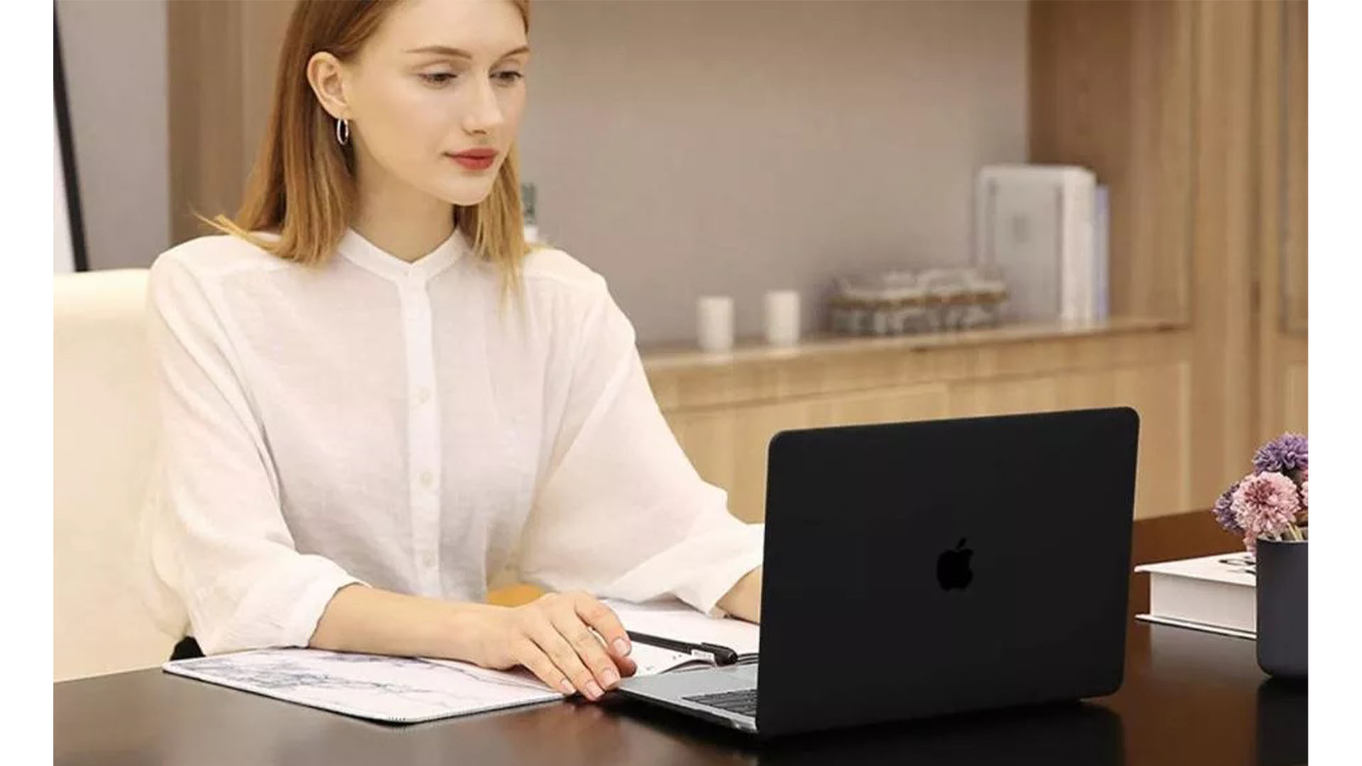 Seorang wanita sedang menggunakan laptopnya yang ditutupi oleh Mosiso Plastic Hard Case Macbook Pro