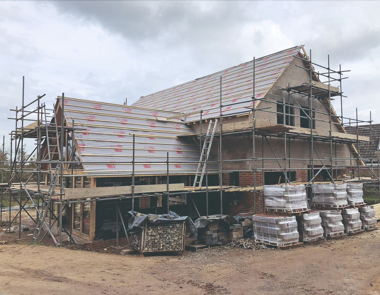 A house on a construction site having its roof installed