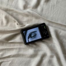 An image of a digital camera on a bedsheet.