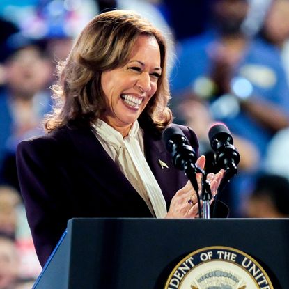 Kamala Harris wears an eggplant purple blazer with a pussy bow blouse