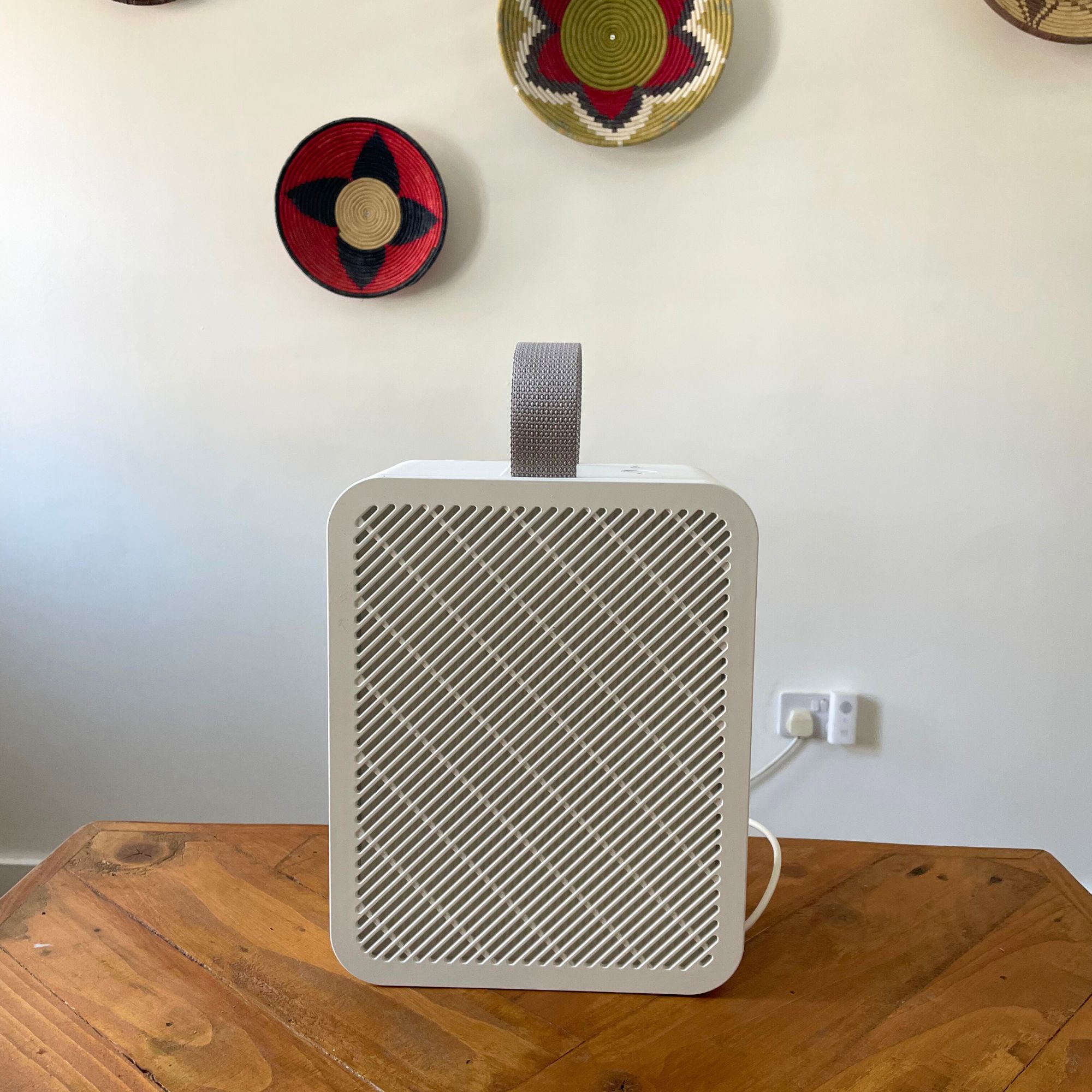 IKEA UPPÅTVIN air purifier sitting on a wooden table in front of a white wall