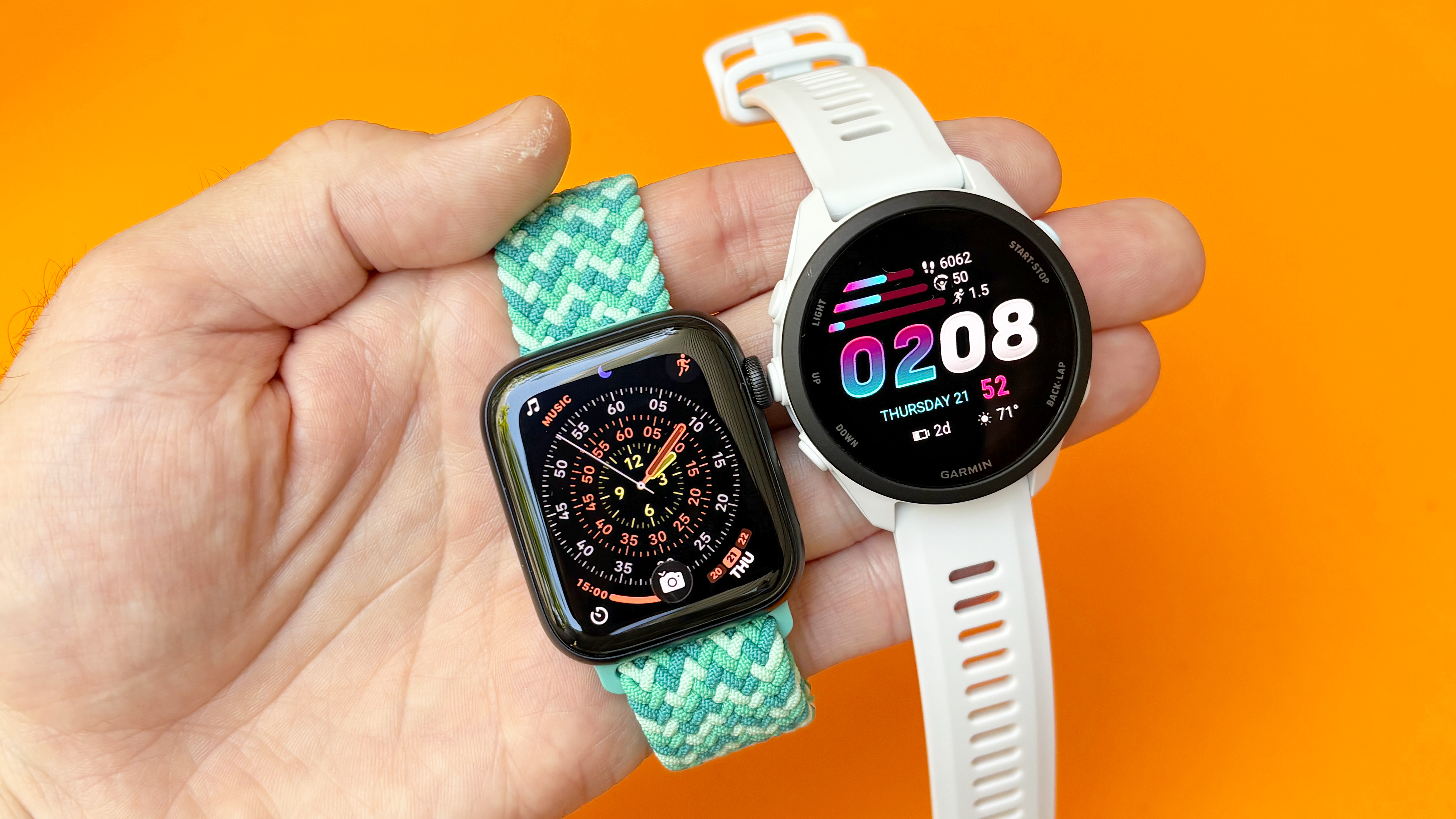Close-up of the Apple Watch SE 3 next to the Garmin Forerunner 70