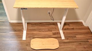 A balance board underneath a standing desk