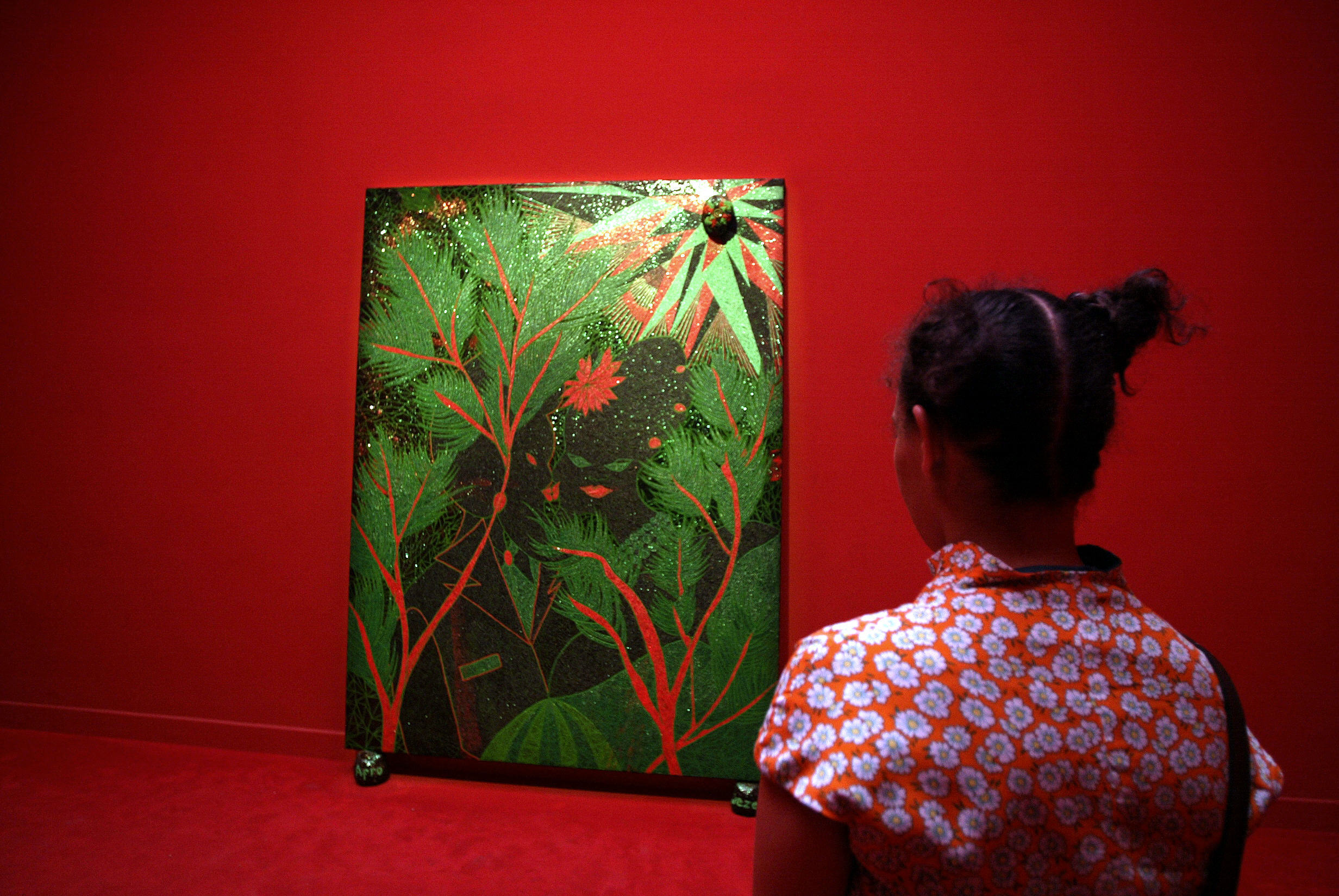 A woman looks at "Forewood" a painting by English artist Chris Ofili at the Great Britain Pavillon during the 5Oth Biennale of Art in Venice, 14 June 2003.