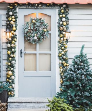 Winter rustic entrance door decorated for New year and Christmas with ornaments, sled with fir tree