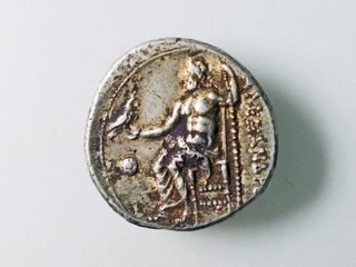 The reverse side of the coin has an image of Zeus and an inscription of Alexander the Great's name.
