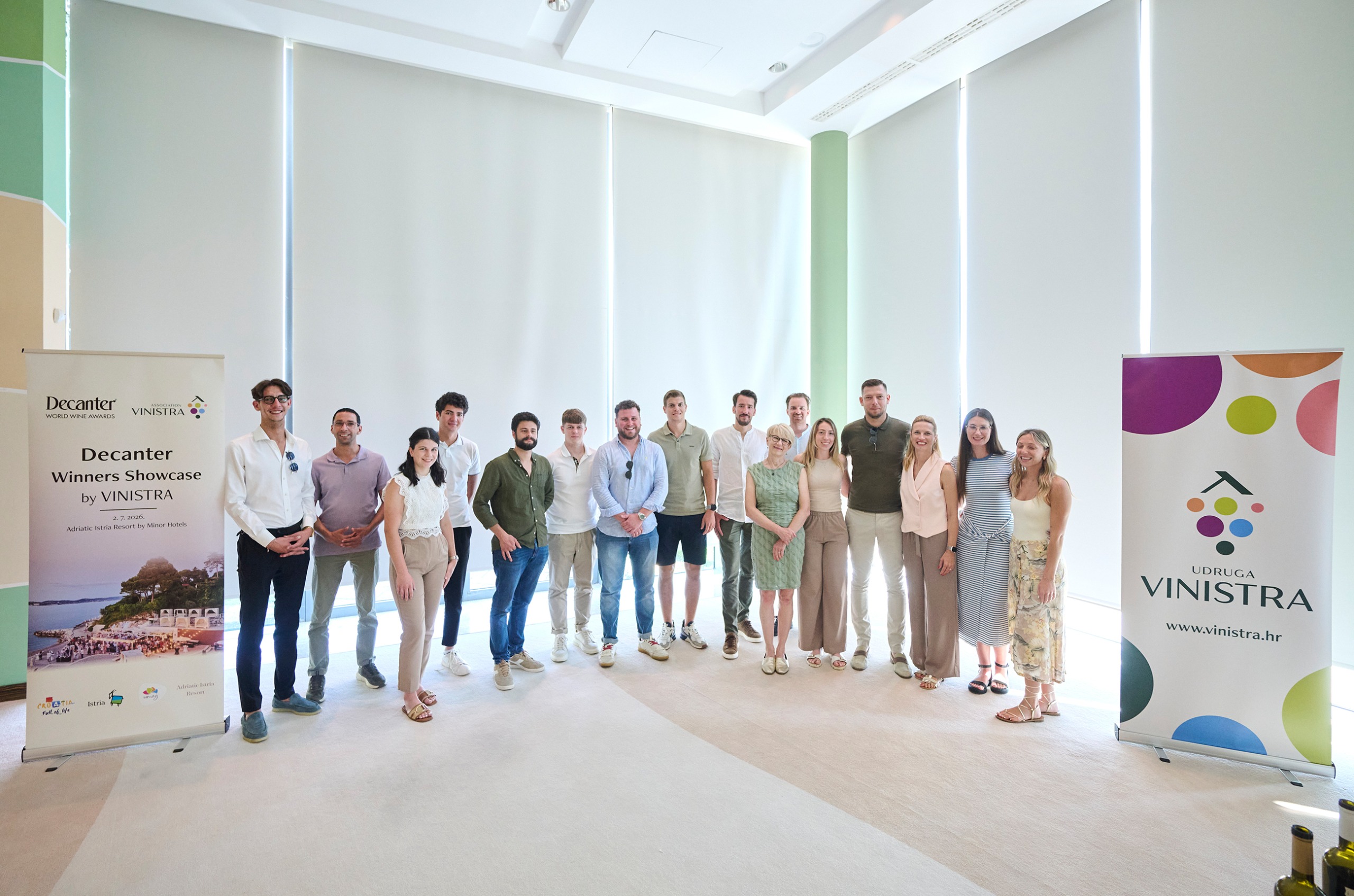 The Gen V group standing in a large room together, with a banner with the Vinistra logo on it