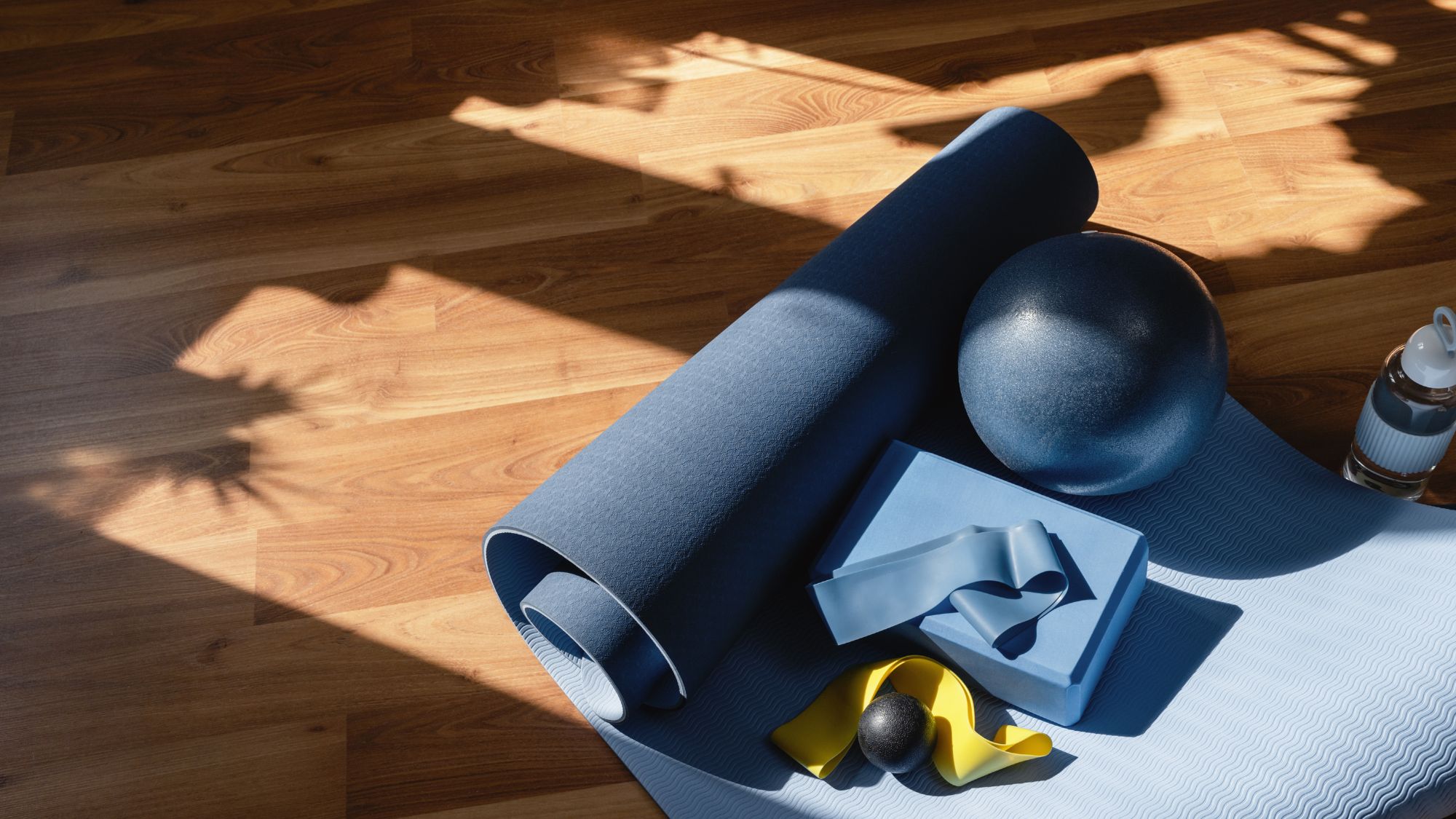 blue at-home pilates equipment on a wooden floor