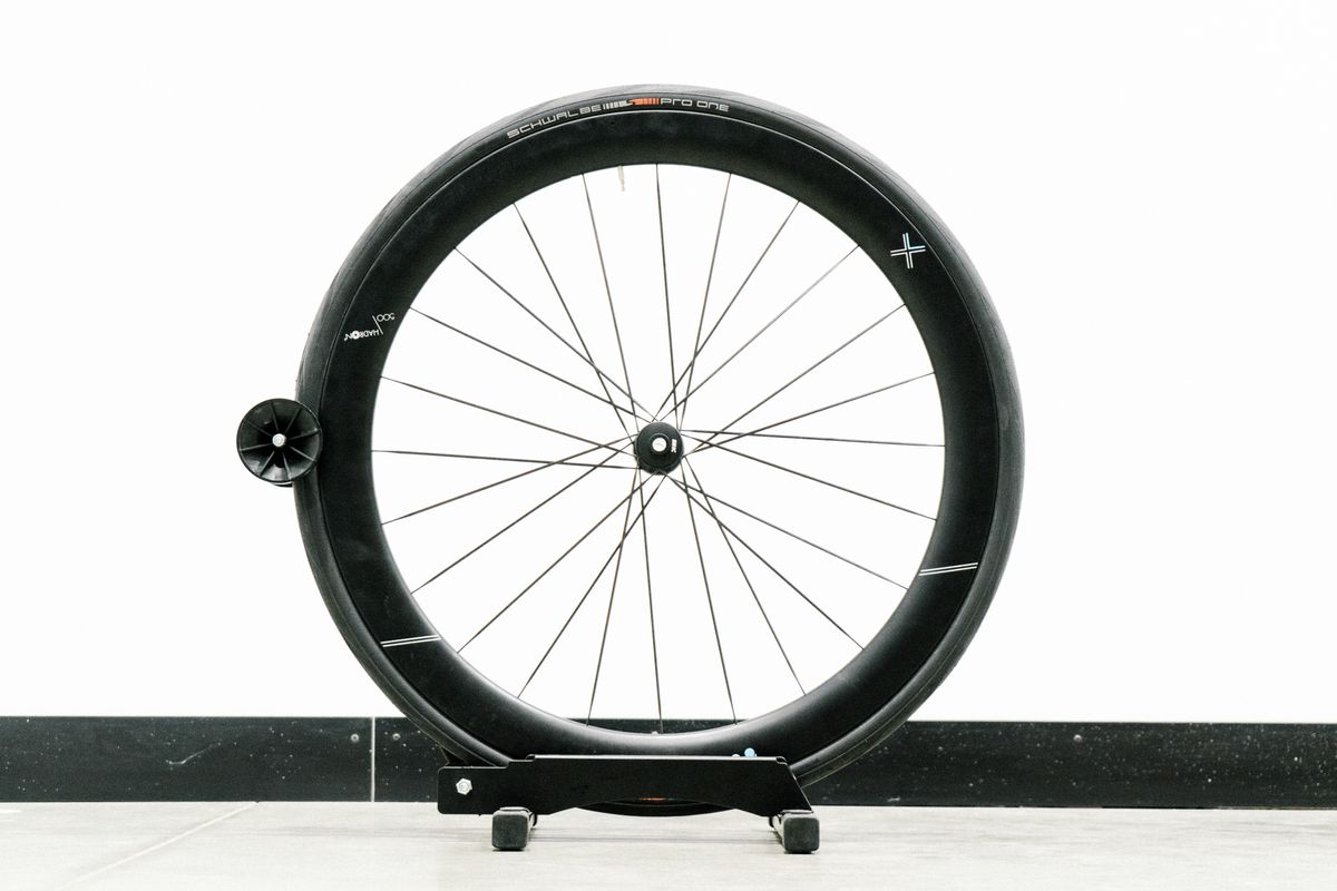 An aero road wheel stands against a white wall
