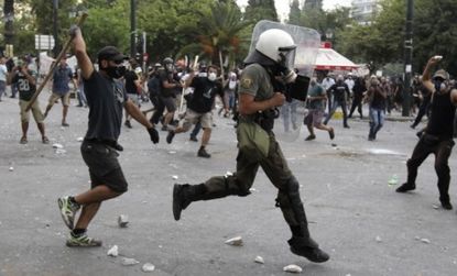 Protesters in Greece raged against policemen Wednesday while Parliament approved the unpopular austerity program.