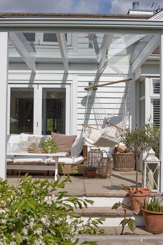 awning over raised patio with hanging chair