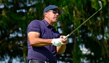 Mickelson strikes his iron shot and watches on 